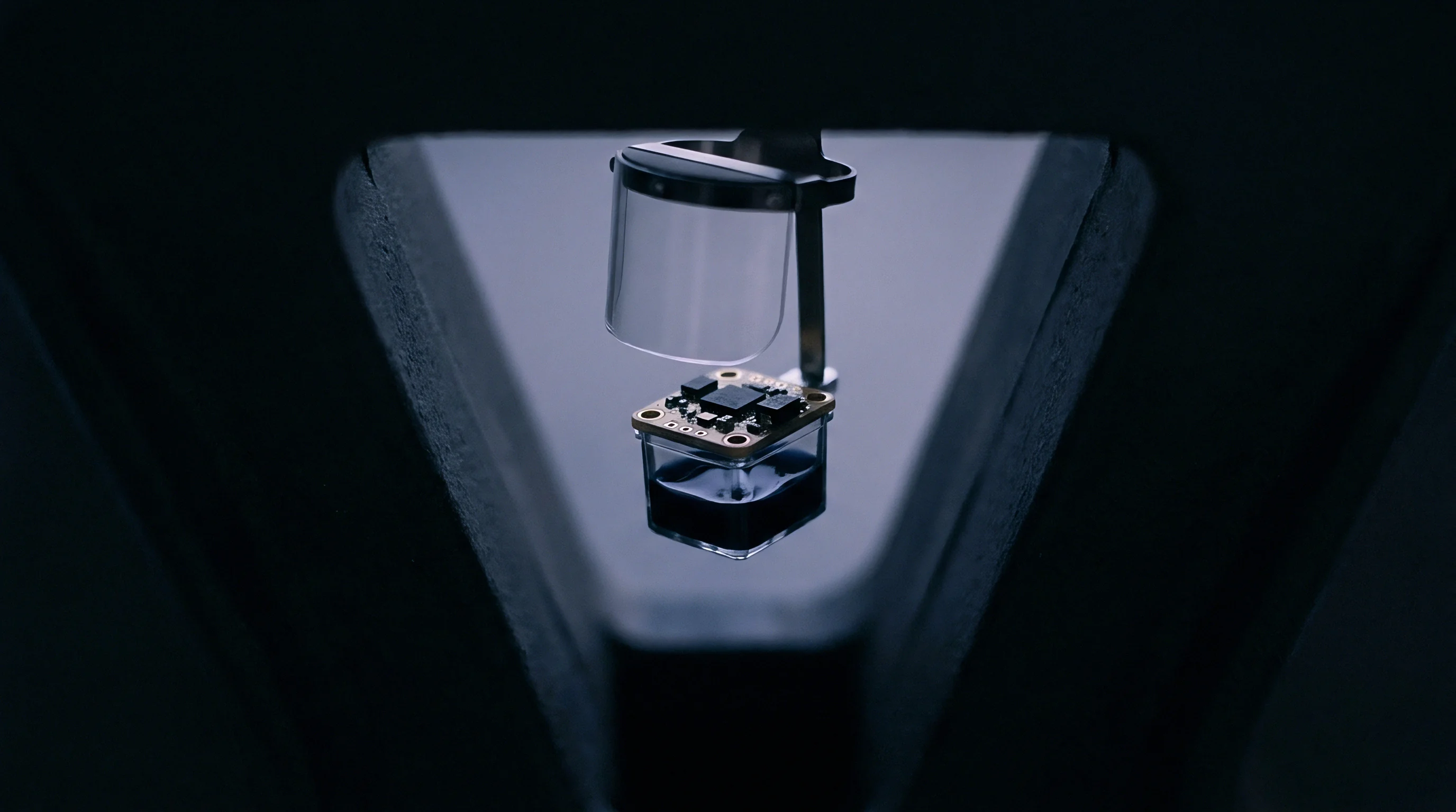 A printed circuit board sensor module sits on a reflective platform beneath a protective clear shield during an automated optical inspection process.